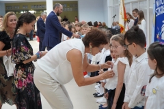 Uczniowie klas pierwszych stojąc na tle napisu Witaj szkoło zostają uroczyście pasowani na pierwszaków przez dyrekcję szkoły, wychowawców, nauczycieli i zaproszonych gości.