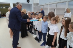 Uczniowie klas pierwszych stojąc na tle napisu Witaj szkoło zostają uroczyście pasowani na pierwszaków przez dyrekcję szkoły, wychowawców, nauczycieli i zaproszonych gości.