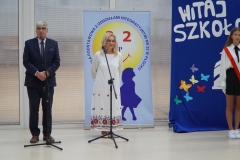 Pan dyrektor oraz zastępca dyrektora szkoły na tle napisu Witaj szkoło witają przybyłych na uroczystość  pierwszoklasistów i ich rodziców.