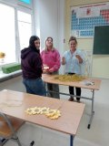 Dwie uczennice klas 7 oraz p. Aneta Szatkowska, wykonujące, z rozłożonych na ławce materiałów, słoneczniki.