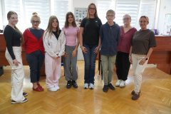 W przestronnej, jasnej sali pozują do zdjęcia- od lewej: członkini Rady SU- Kornelia, Pani Dyrektor, Zastępczyni Przewodniczącego- Zofia, Członkini Rady- Halina, Sekretarz Rady- Magdalena, Przewodniczący Rady- Ryszard, Pani Wicedyrektor i opiekunka SU. Wszyscy są w pogodnych nastrojach.