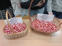 dwa kosze wiklinowe z ogromną ilością biało-czerwonych kotylionów