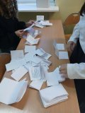 Zbliżenie na łaekę szkolną, na której segregowane i liczone są wypełnione karty do głosowania w wyborach do Rady SU.