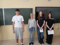 Trzy uczestniczki koła SU wraz z uhonorowanym „Najsympatyczniejszym Chłopakiem w klasie”, który na szyi ma zawieszony okrągły, niebieski medal. Wszyscy są uśmiechnięci.