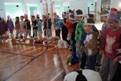 Dzieci, stanowiące widownię oraz członkowie koła teatralnego, mające na głowach opaski z wizerunkiem misia, pokazują gesty zgodnie ze słowami wymawianej rymowanki.