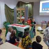 Dwóch chłopców nakrywa zastawą świąteczny stół.