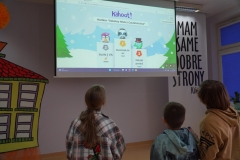 Uczniowie odczytują wyniki konkursu „Mistrz Czytelnictwa” z tablicy.