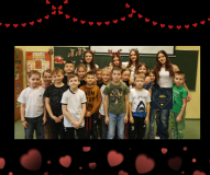 Na zdjęciu widoczna jest grupa dzieci oraz dziewczynki ze Szkolnego Klubu Wolontariatu, stojące razem w sali lekcyjnej. Osoby ustawione są w dwóch rzędach. Dzieci stoją blisko siebie, patrzą w stronę aparatu, większość ma neutralny lub lekko uśmiechnięty wyraz twarzy.