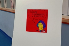 Plakat "Tydzień z Kopernikiem w Bibliotece" na sztaludze.