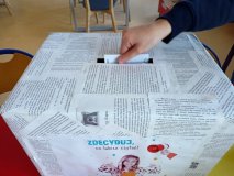 Pudło będące urną wyborczą, z wyciętym otworem do wrzucania propozycji książkowych do kupienia.