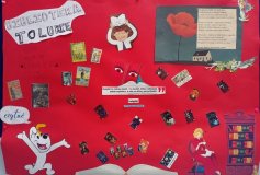 Plakat kolaż - na czerwonym tle przyklejone różne symbole kojarzone z książka i biblioteką: otwarta książka, postać Reksia z bajki, regał z książkami, postać zajęta czytaniem, okładki książek, cytat: „Książki to także świat, i to świat, który człowiek, a nie na który przychodzi”.