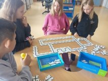 cztery Uczennice układają z puzzli trasy dla mini robotów – ozobotów