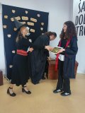 kobieta i mężczyzna – bibliotekarze w strojach czarodziejów wręczają nagrodę i gratulują Uczennicy, która brała udział w konkursie na najciekawsze przebranie w stylu bohaterów książek o Harrym Potterze, uczennica jest przebrana za Hermionę