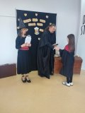 kobieta i mężczyzna – bibliotekarze w strojach czarodziejów wręczają nagrodę i gratulują Uczennicy, która brała udział w konkursie na najciekawsze przebranie w stylu bohaterów książek o Harrym Potterze, uczennica jest przebrana za Hermionę