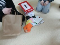 Na podłodze siedzą dwie osoby ze stosem kolorowych kart, segregując je w ramach akcji walentynkowej. 