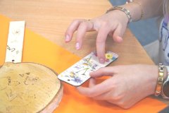 Naklejanie serwetki na drewienko metodą decoupage.