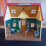 Miniaturowa scenografia do wiersza Wisławy Szymborskiej „Kot w pustym mieszkaniu” – wnętrze małego domku z samotnym brązowym kotkiem.