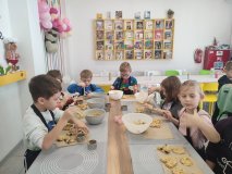 Sześcioro uczniów klas pierwszych formuje na podkładce, za pomocą odpowiednich foremek, masę owsianą, z której następnie zostaną upieczone ciasteczka.