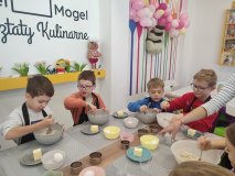 Uczniowie łączą w misce wszystkie produkty potrzebne do upieczenia ciasteczek owsianych. 