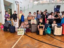 Na sali gimnastycznej inna część dużej grupy uczniów klas 1-3 w wymyślnymi zamiennikami plecaków w rękach. Wszyscy uśmiechnięci i w dobrych nastrojach.