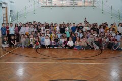 Na sali sportowej bardzo duża grupa uczniów klas 1-3 w bardzo szalonych fryzurach. Wszyscy radośni i uśmiechnięci.