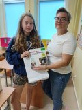 Uczennica Wiktoria Rychlik odbiera z rąk nauczycielki języka niemieckiego pani Moniki Kopki-Wonsowskiej nagrodę książkową za najlepszy wynik testu z wiedzy o krajach niemieckiego obszaru językowego.