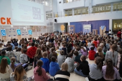 Grupa nauczycieli, uczniów tworzących widownię oraz aktorów ogląda prezentację multimedialną wyświetlaną na jednej ze ścian forum. Jej treść omawia koordynator spotkania- p. Anna Kowalska.