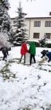 Grupa dzieci lepi bałwana.