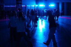 foto_11 uczniowie i uczennice tańczący na formu szkoły w blasku kolorowych świateł