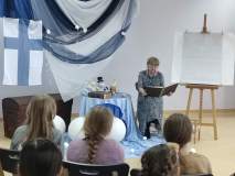 Spotkanie z Muminkami w bibliotece dla uczniów klas trzecich. Nauczycielka czyta fragment książki. 