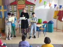 Spotkanie z Pippi w bibliotece dla uczniów klas drugich. Na tle kolorowej dekoracji nauczycielka objaśnia zadania.