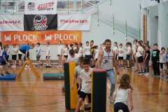 Dzieci wykonujące ćwiczenia gimnastyczne polegające na pokonywaniu toru przeszkód.