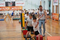 Dzieci wykonujące ćwiczenia gimnastyczne polegające na pokonywaniu toru przeszkód.