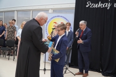 Ksiądz proboszcz Jerzy Ławicki wręcza nagrodę Marcelowi Płoskońskiemu.