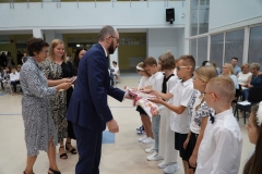 Przewodniczący Rady Rodziców Pan Przemysław Zieliński w towarzystwie wychowawcy Pani Elżbiety Wiśniewskiej wręcza nagrody książkowe uczniom klasy 3b.