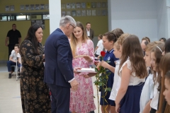 Pan Dyrektor J. Banasiak w towarzystwie wychowawcy Pani Natalii Szwech wręcza nagrody książkowe uczniom klasy 3c.