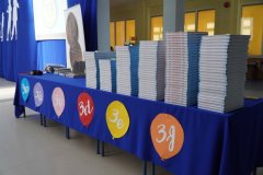 Leżące na stolikach pamiątkowe książki dla uczniów klas trzecich i nagrody dla laureatów konkursów.
