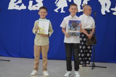 Dwoje dumnych laureatów ogólnopolskiego konkursu ,,Olimpusek”  z matematyki trzymający w dłoniach pamiątkowe książki i dyplomy.