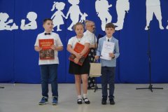 Troje laureatów szkolnego konkursu ortograficznego ,,O pióro dyrektora szkoły” dumnie prezentuje pamiątkowe książki i dyplomy za udział w konkursie.