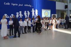 Uczniowie klasy 3d otrzymują na forum szkoły pamiątkowe książki i dyplomy z okazji ukończenia pierwszego etapu edukacyjnego.