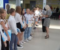 Uczniowie klasy 3f otrzymują na forum szkoły pamiątkowe książki i dyplomy z okazji ukończenia pierwszego etapu edukacyjnego.