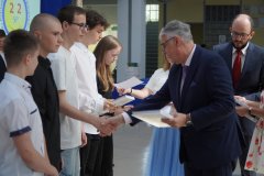 Dyrektor szkoły wręcza nagrody uczniom klasy 8B. 