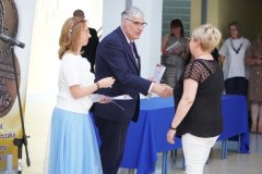 Dyrektor szkoły wraz z wychowawcą kl 8B wręczają list gratulacyjny.