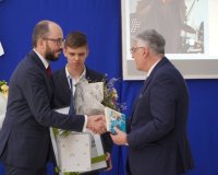 Przewodniczący Rady Rodziców pan Przemysław Zieliński wręcza kwiaty dyrektorowi szkoły. 