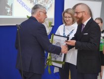 Dyrektor Janusz Banasiak odbiera upominek z rąk przedstawicieli Rady Pedagogicznej oraz pracowników administracji i obsługi. 