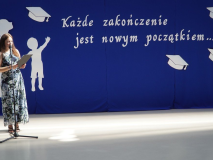 Na tle okolicznościowej dekoracji, z sentencją „Każde zakończenie jest nowym początkiem...”, widać Panią Natalię Szwech – prowadzącą uroczystość zakończenia roku szkolnego 2025/2026.