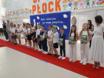 Na tle okolicznościowej dekoracji widać Uczniów klasy 3a po otrzymaniu nagród – pamiątek ukończenia I etapu edukacji. Towarzyszy Im Wychowawczyni- Pani Anna Figurska, Nauczycielka współorganizująca kształcenie- Pani Joanna Poddenek, Zastępca Prezydenta Miasta Płocka ds. Polityki Społecznej- Pan Łukasz Jankowski oraz Przewodniczący Rady Rodziców- Pan Przemysław Zieliński.