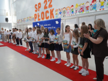 Na tle okolicznościowej dekoracji widać Uczniów klasy 3b po otrzymaniu nagród – pamiątek ukończenia I etapu edukacji. Towarzyszy Im Wychowawczyni- Pani Katarzyna Zaleska, Nauczycielka współorganizująca kształcenie- Pani Anna Ejnik oraz Pani Dyrektor Marlena Błachowicz.