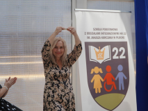 Na zdjęciu widać Panią Dyrektor Marlenę Błachowicz, która trzyma w uniesionych rękach pamiątkę otrzymaną od Uczniów klas trzecich- szklane serce za serce oddane naszej Szkole.