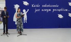 Na scenie stoją prowadzący uroczystość zakończenia roku klas ósmych – Nauczyciel i Uczeń.